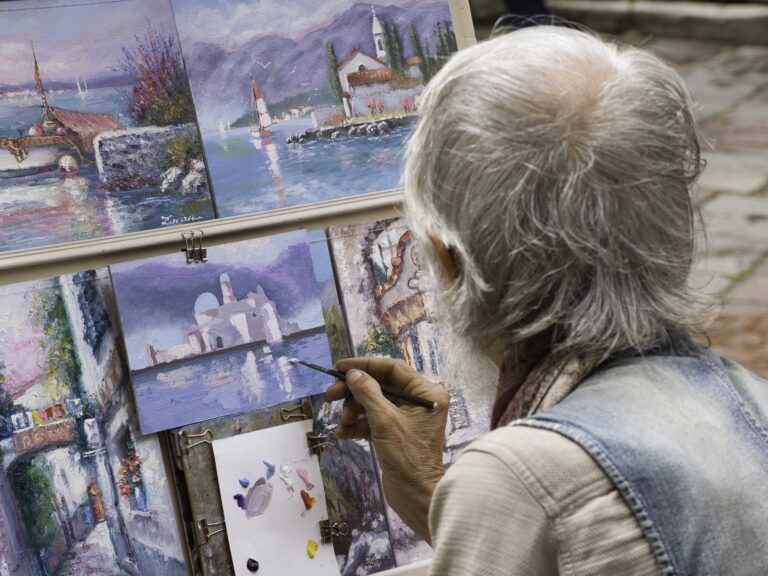 A painter brushing paint onto a canvas.